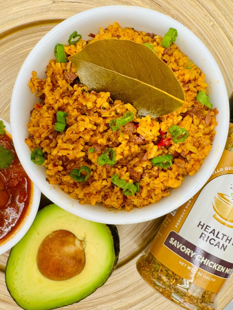 Closeup of plant based arroz con pollo rice topped with green onions and bay leaf, ideal for vegan meal prep ideas.